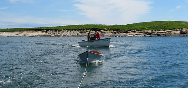 motor boats leaving a low rocky island